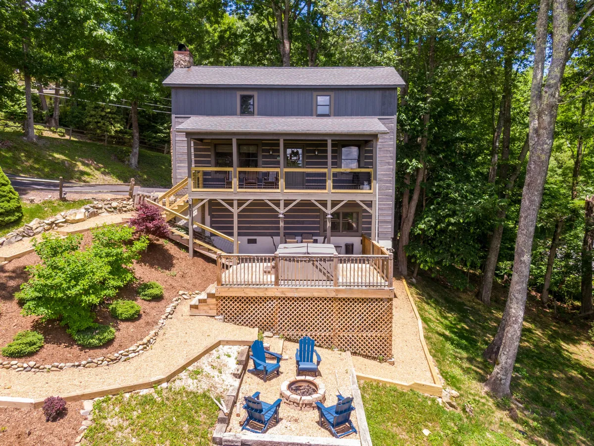 A view of the house exterior with an inviting outdoor seating area, fire pit, and lush greenery. The space is ideal for group gatherings, family barbecues, or simply relaxing after a trail adventure. The open lawn echoes the section’s theme of pet-friendly enjoyment.