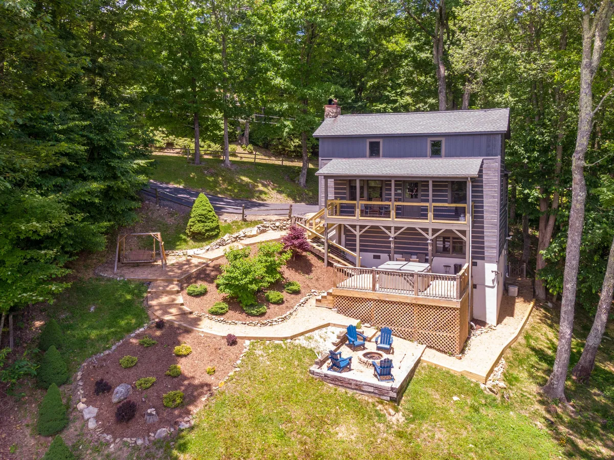 This exterior scene captures the main house with a spacious deck, comfortable seating area, and manicured landscaping. The area clearly invites outdoor relaxation, with ample space for children to play and families to gather. The view suggests a safe and welcoming environment perfect for family activities.